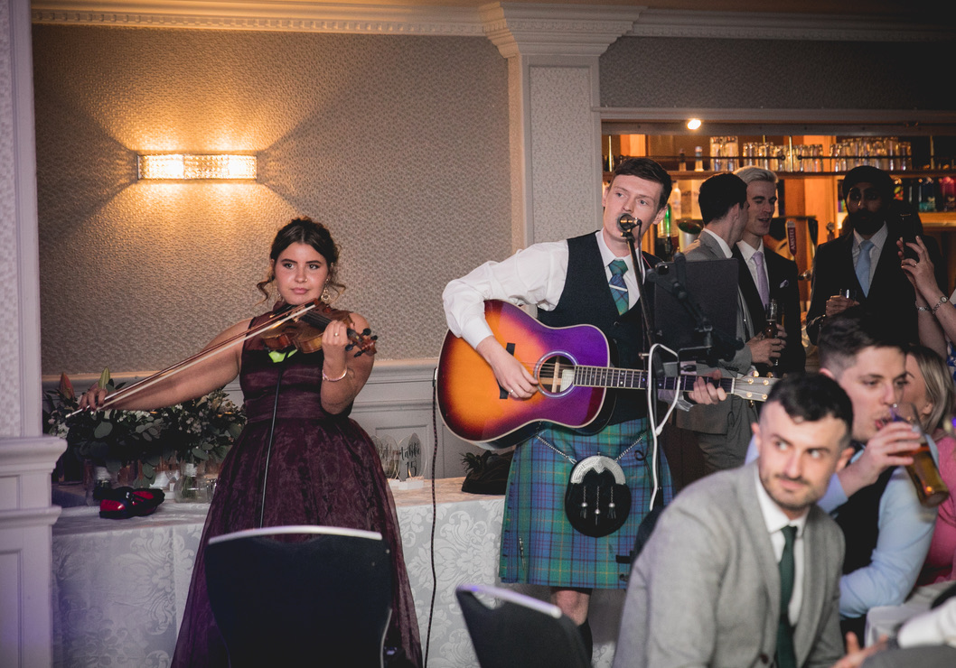 KIN’s fiddle player and singer performing among wedding guests